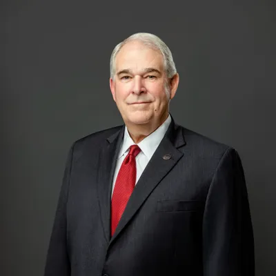William H. Hayter in dark black suit with red tie