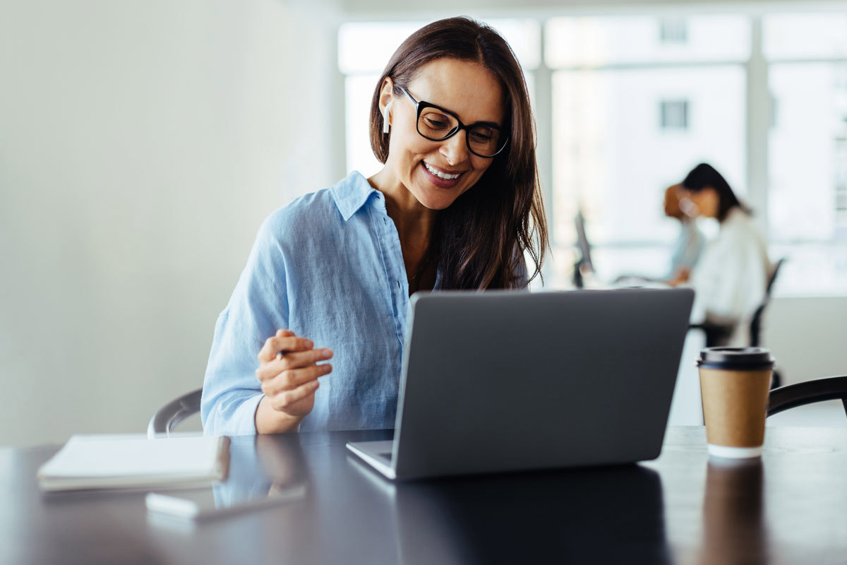 Woman With Glasses Smiling At Laptop