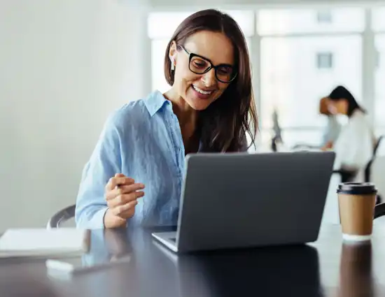 Woman With Glasses Smiling At Laptop