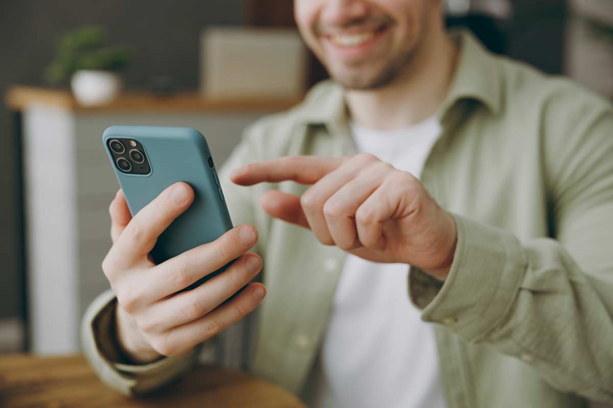 Man Lifting Finger To Use Blue Cell Phone