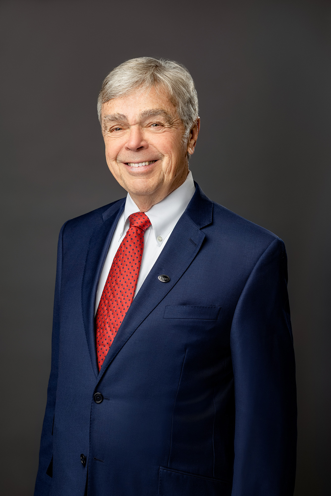 David A. Leonard in a dark blue suit and red tie
