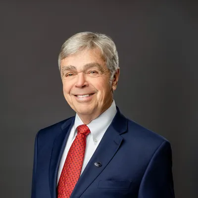 David A. Leonard in a dark blue suit and red tie