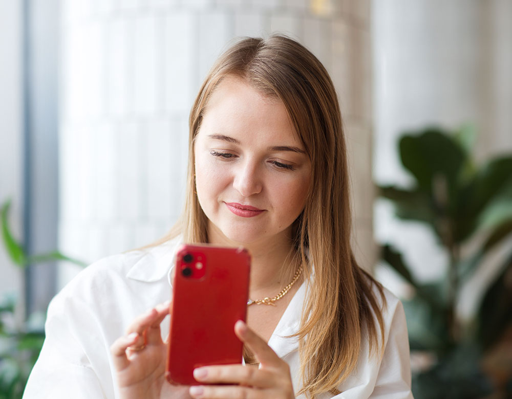 Blonde woman looking at red phone