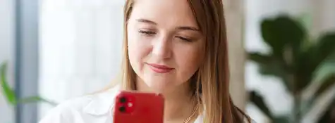 Blonde woman looking at red phone