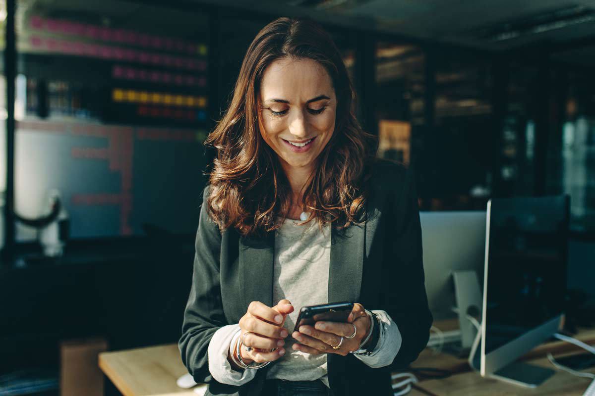 Long Haired Brunette Woman Smiling At Phone