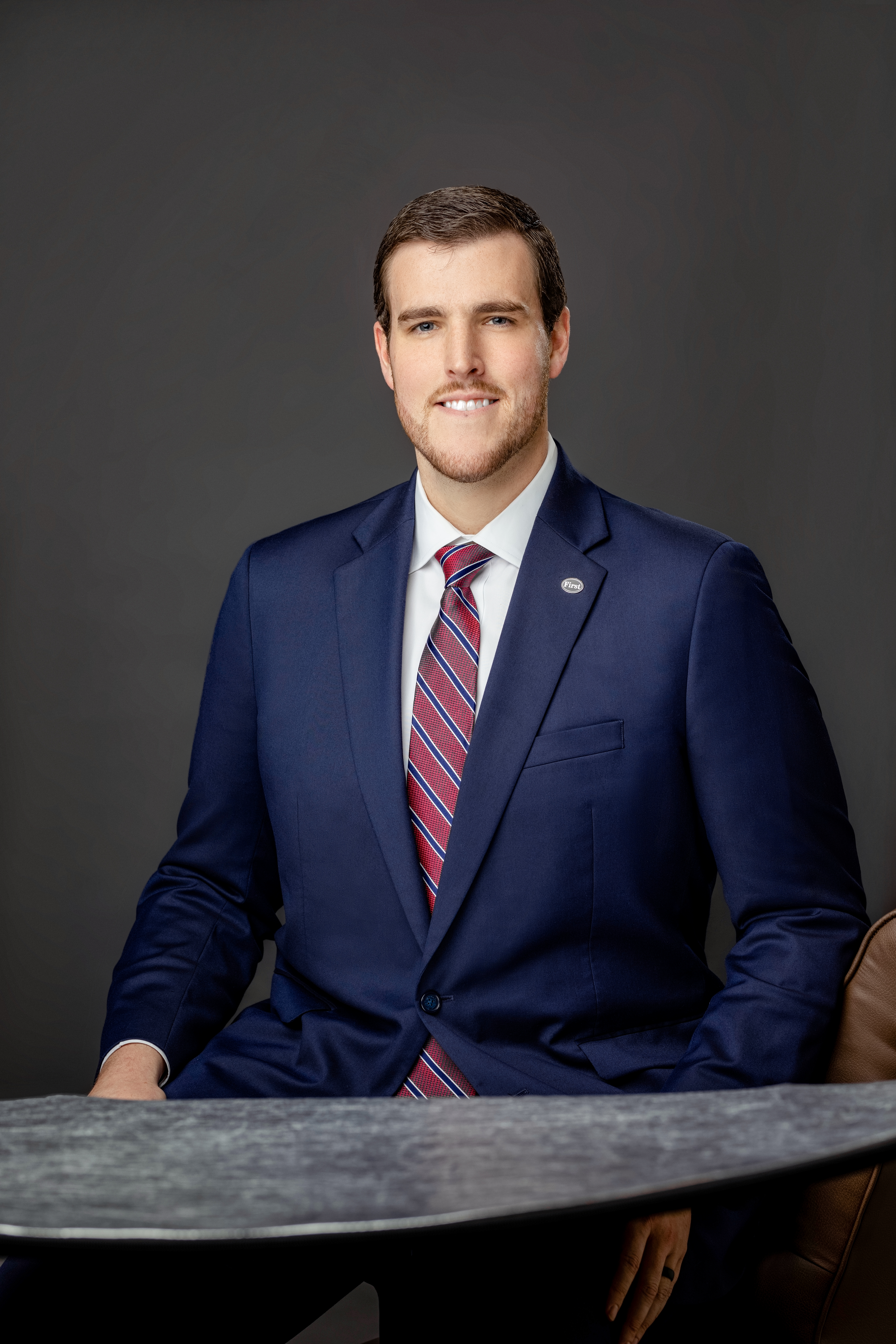 Raleigh E. Hayter in dark blue suit with maroon patterned tie