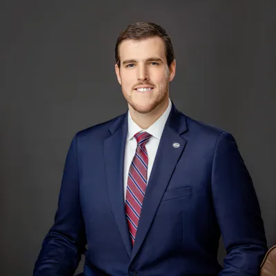 Raleigh E. Hayter in dark blue suit with maroon patterned tie
