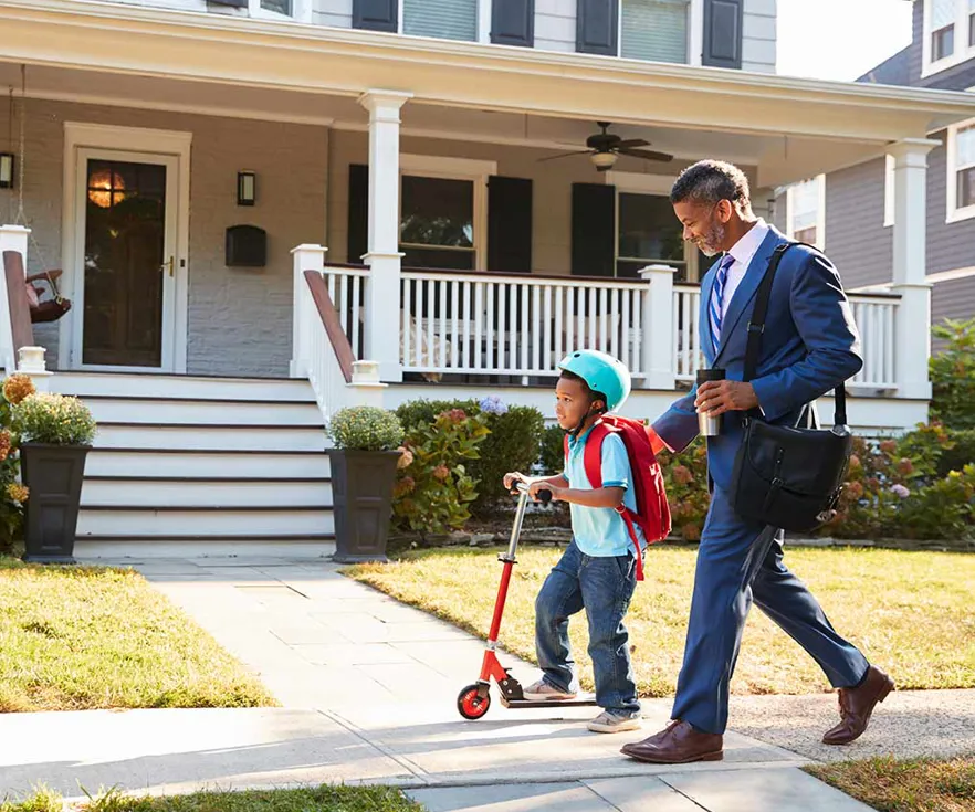 Black Man In Suit Walking With Scootering Son To School