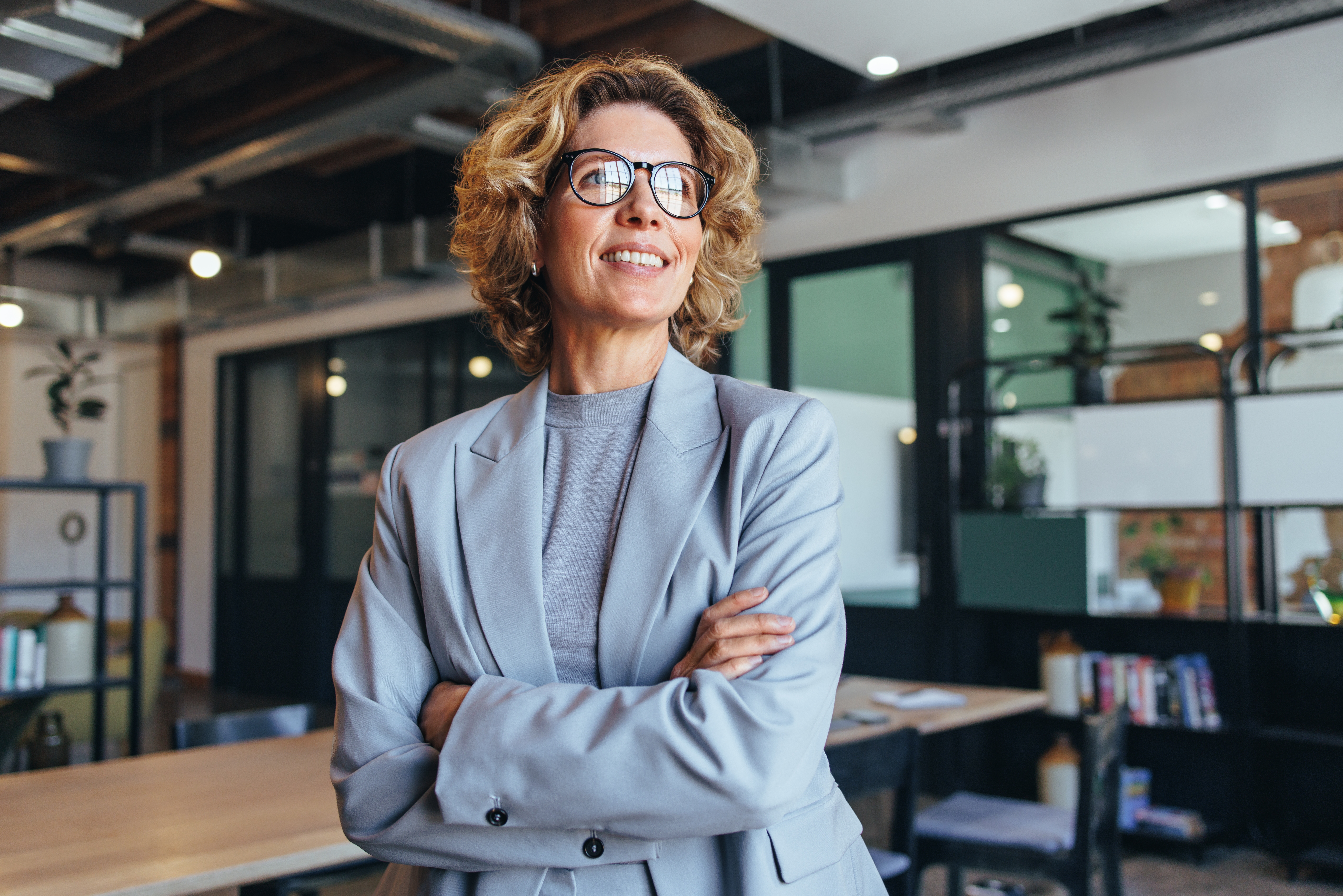 Woman Standing In Office Looking Out Window