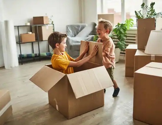 Boys Playing With Boxes In New Home