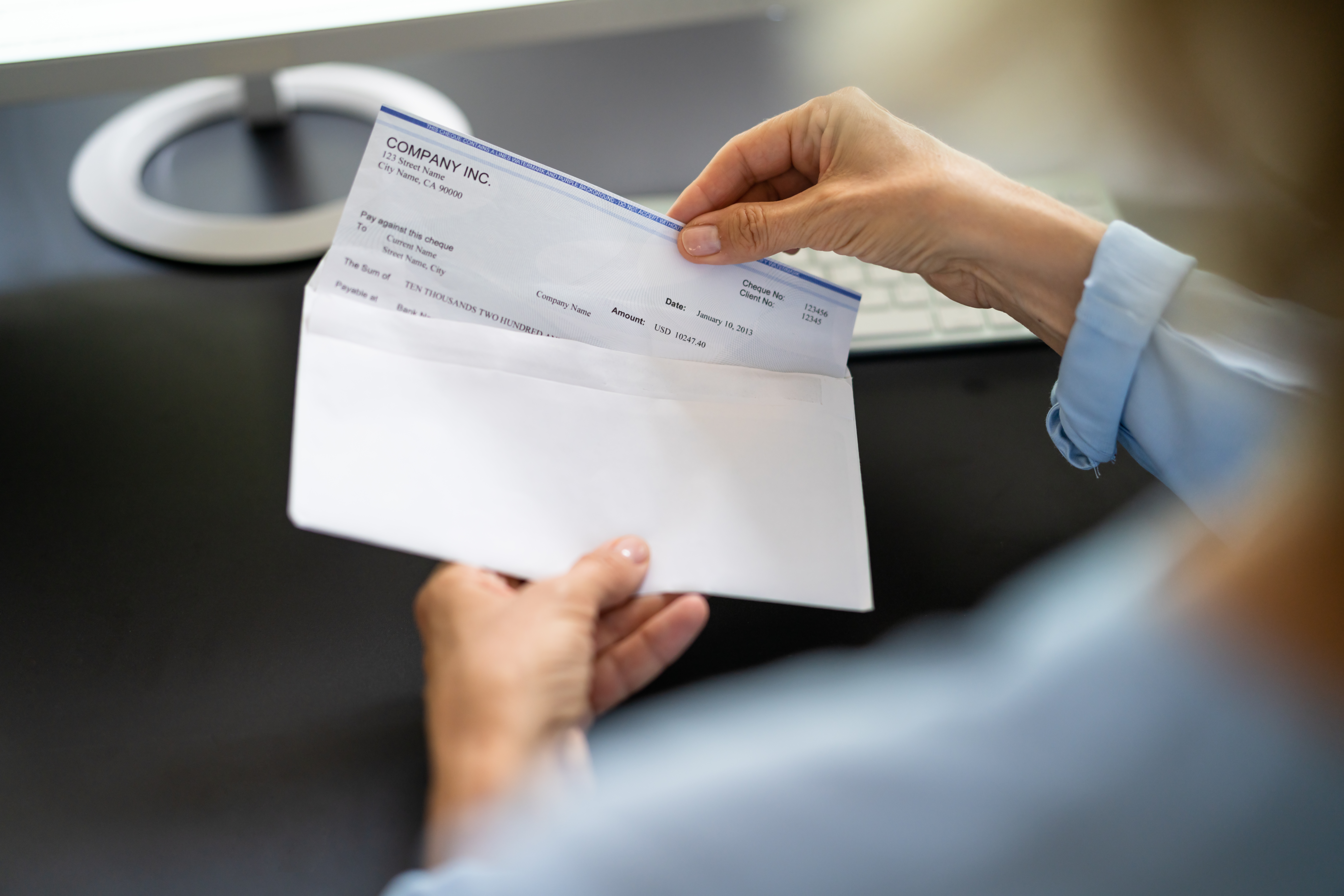 Business owner pulls paper check out of envelope