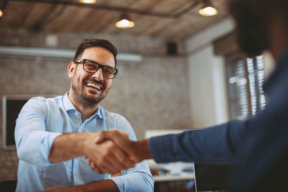 Man In Blue Button Up Shaking Hands