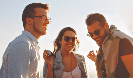 Three friends smiling and dancing