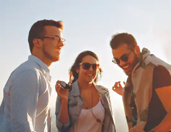 Three friends smiling and dancing