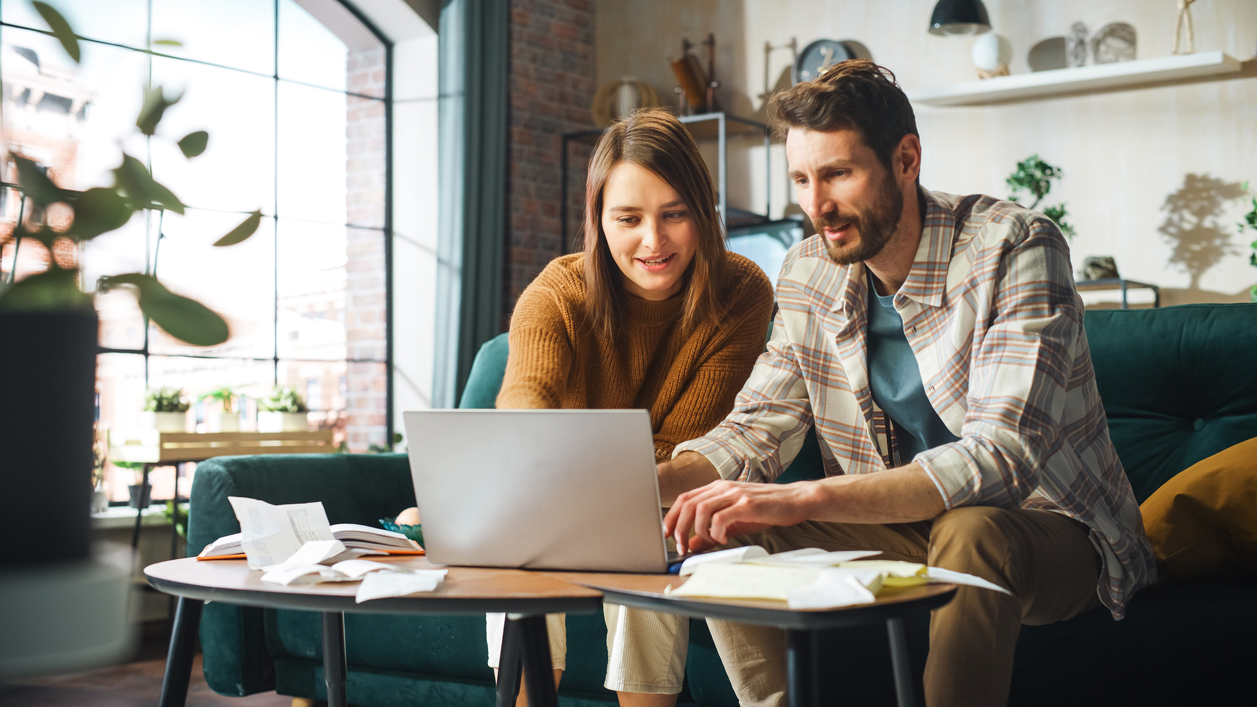 Couple sitting in living room in front of an open laptop