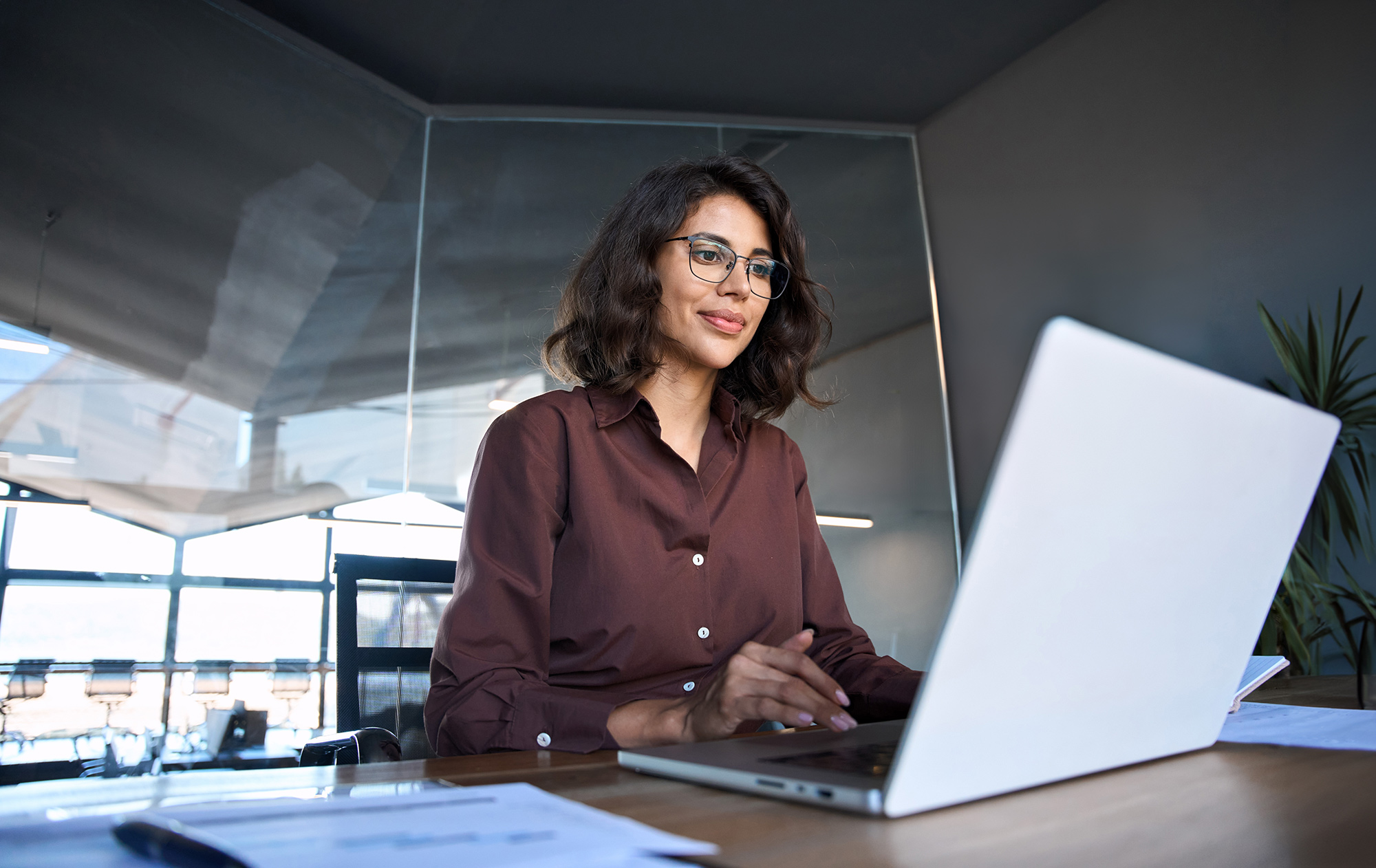 Businesswoman sitting at desk using laptop computer