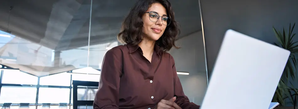 Businesswoman sitting at desk using laptop computer