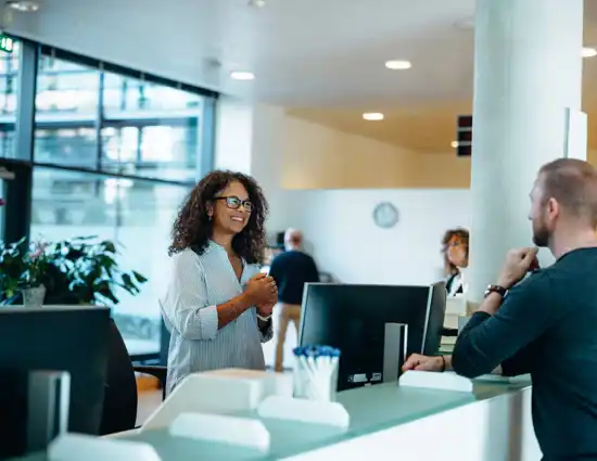 Woman With Curly Hair Smiling Talking To Guests