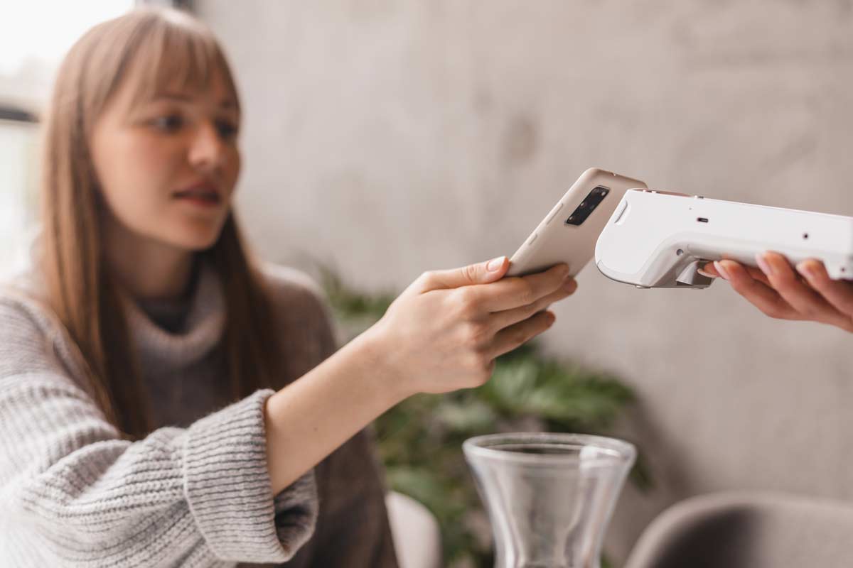 Woman Holding Phone To Google Card Reader
