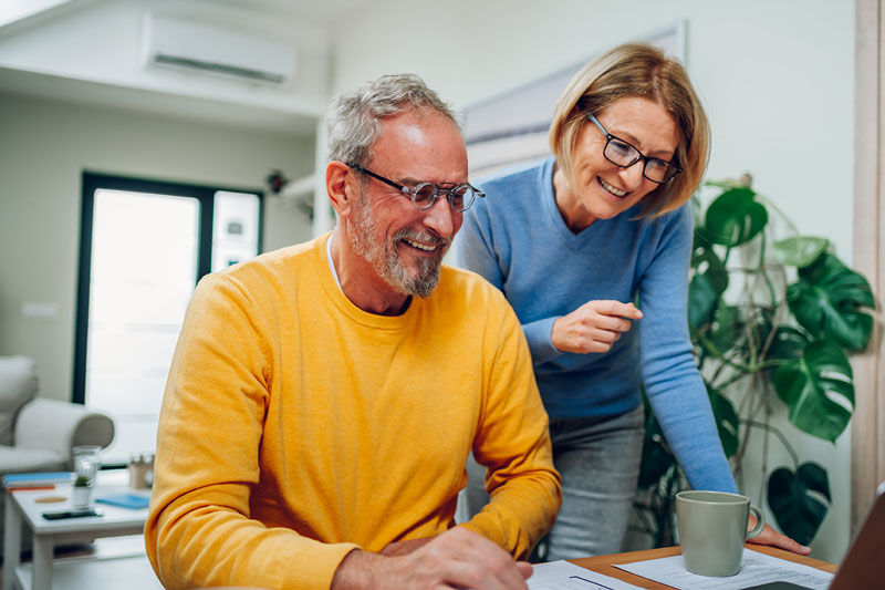 Senior Middle Aged Happy Couple Using Laptop