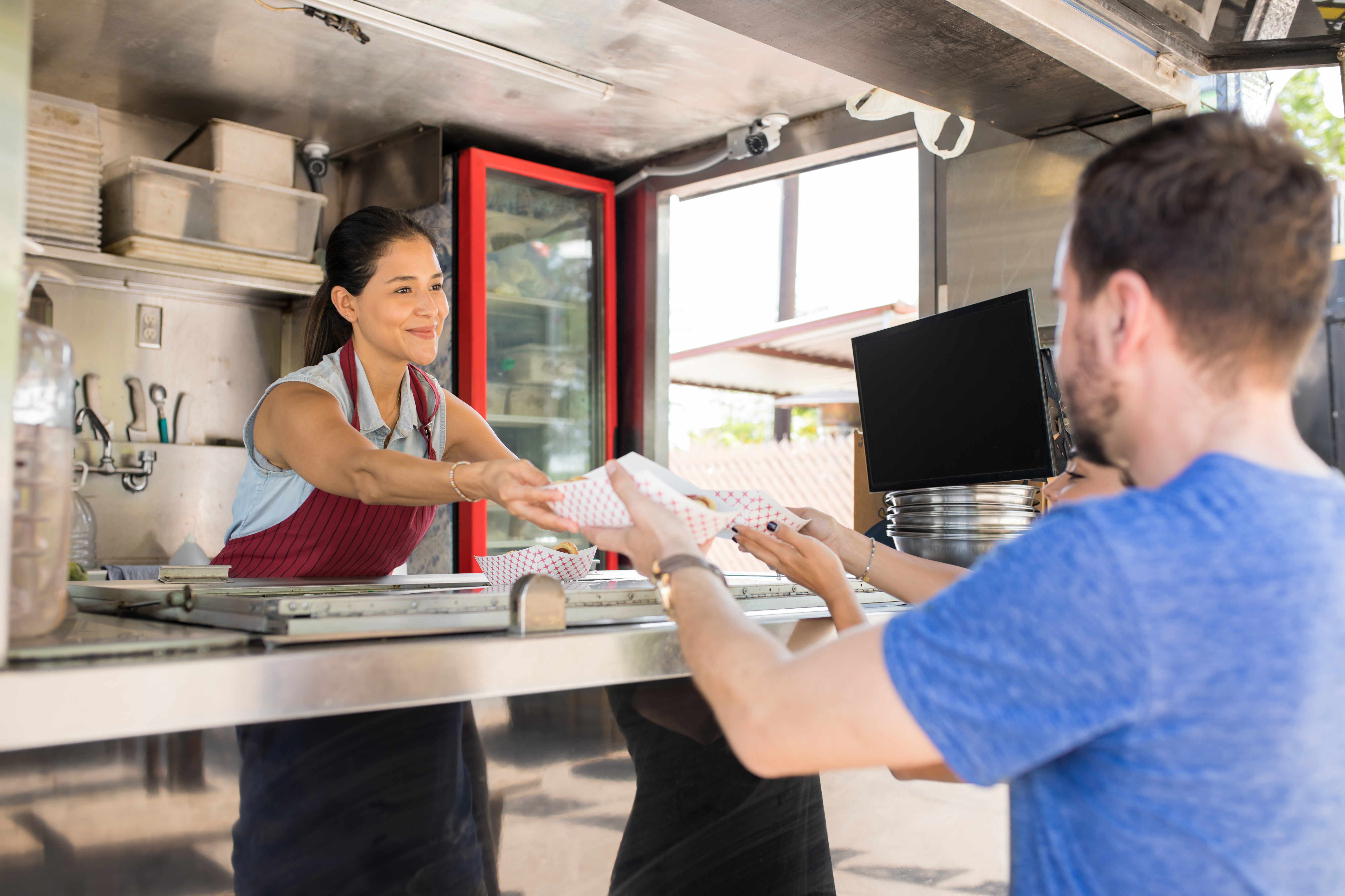 Woman serves food to customers from food truck 