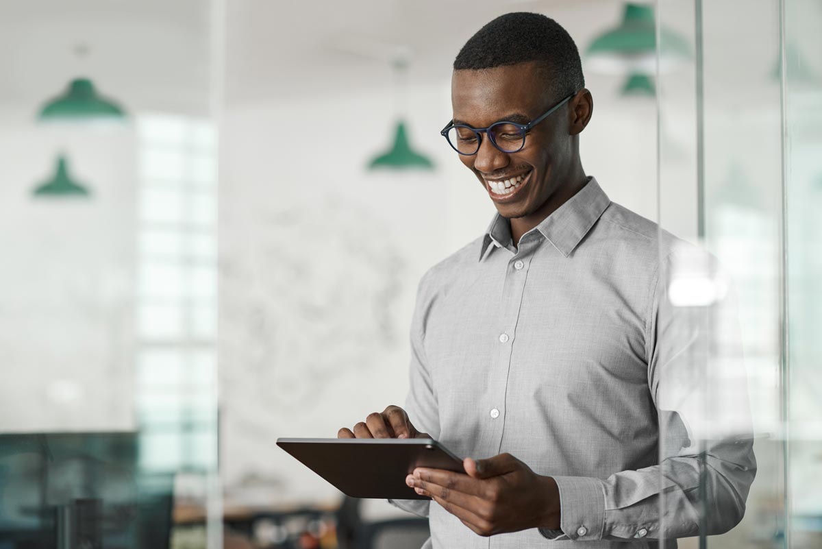 African American Man Smiling At Tablet